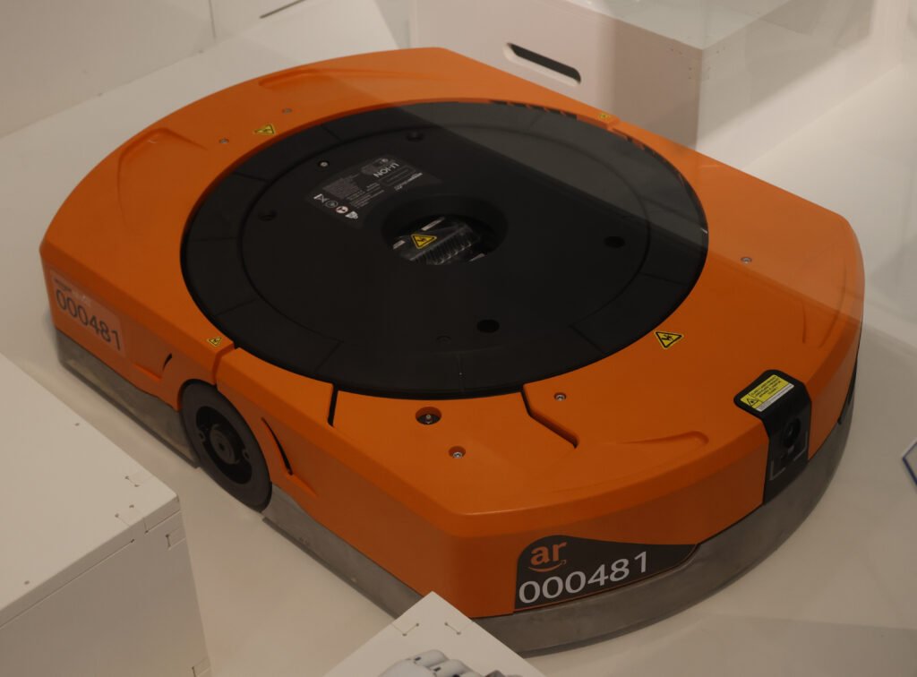 An Amazon warehouse robot moving inventory shelves